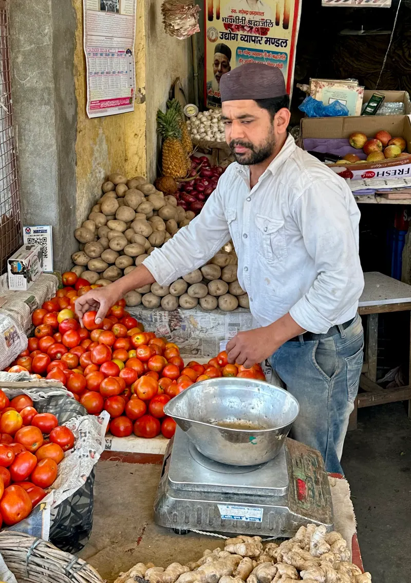 A vendor weighing produce at an Indian mandi, one of the buyer types listed on MushroomBazaar